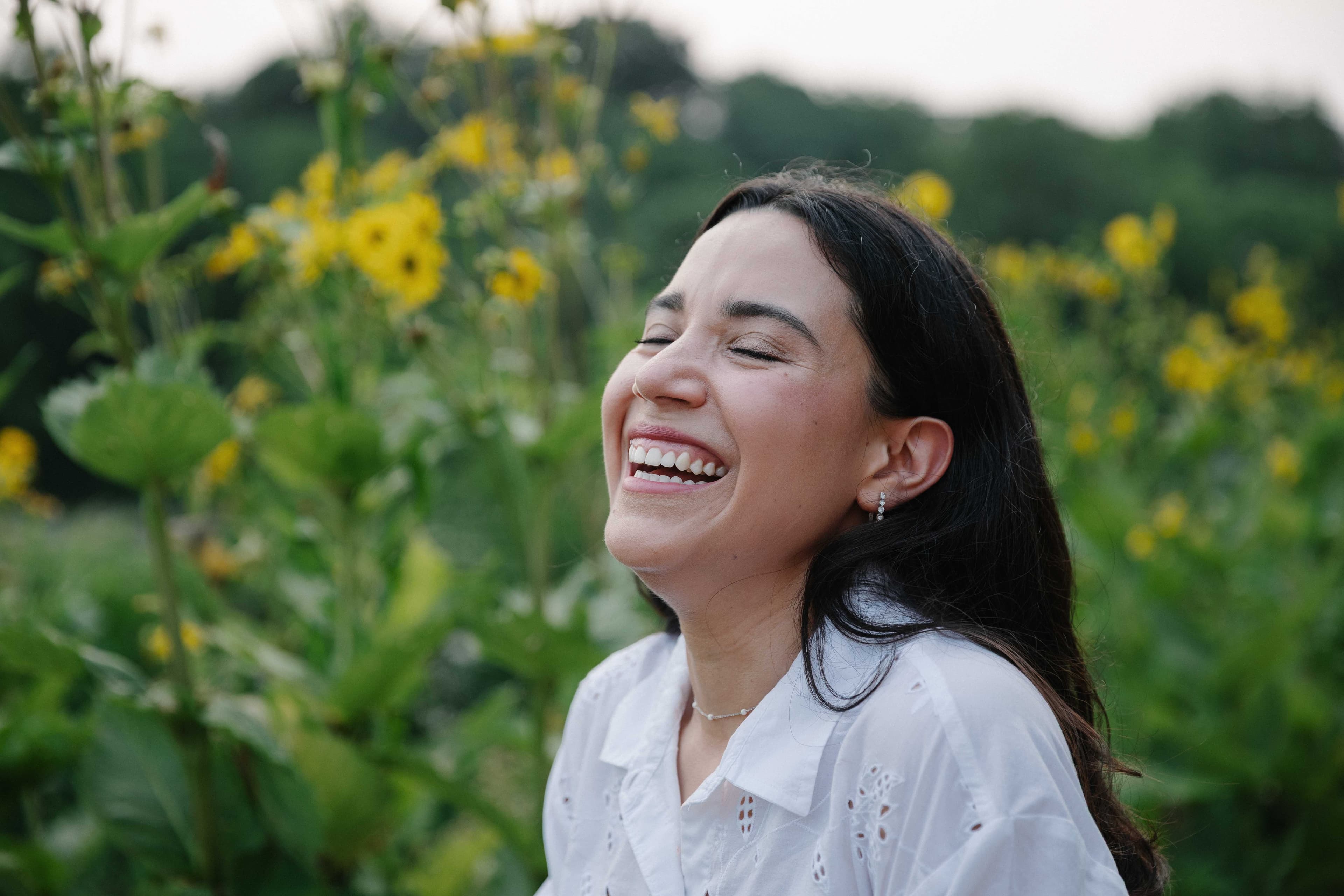 Maria Escamilla, DNP, CNM, laughing outdoors among the prairie wildflowers